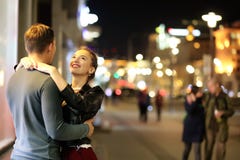 Pares bonitos em uma data em uma cidade da noite foto de stock Pares bonitos em uma data em uma cidade da noite foto de stock
