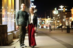 Pares bonitos em uma data em uma cidade da noite foto de stock Pares bonitos em uma data em uma cidade da noite foto de stock