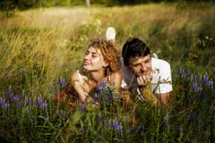 Pares de amor novos que apreciam a natureza, guardando as mãos e andando no campo com alfazema Povos bonitos na natureza na mola fotos de stock Pares de amor novos que apreciam a natureza, guardando as mãos e andando no campo com alfazema Povos bonitos na natureza na mola fotos de stock