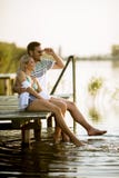 Pares de amor que sentam-se no cais no lago fotos de stock Pares de amor que sentam-se no cais no lago fotos de stock