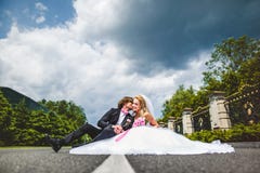 Pares de la boda que se sientan en la tierra imagenes de archivo Pares de la boda que se sientan en la tierra imagenes de archivo