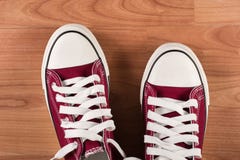Pares de zapatillas de deporte rojas en piso de madera Fotografía de archivo libre de regalías Pares de zapatillas de deporte rojas en piso de madera Fotografía de archivo libre de regalías