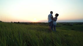 Pares embarazadas felices jovenes románticos que abrazan en naturaleza en la puesta del sol almacen de metraje de vídeo Pares embarazadas felices jovenes románticos que abrazan en naturaleza en la puesta del sol almacen de metraje de vídeo
