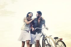 Pares en el amor que empuja la bicicleta junto foto de archivo Pares en el amor que empuja la bicicleta junto foto de archivo