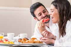 Pares en la albornoz que se divierte que come la fruta imágenes de archivo libres de regalías Pares en la albornoz que se divierte que come la fruta imágenes de archivo libres de regalías
