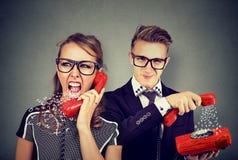 Pares enojados que tienen conversación telefónica desagradable, mujer que grita en el hombre fotos de archivo libres de regalías Pares enojados que tienen conversación telefónica desagradable, mujer que grita en el hombre fotos de archivo libres de regalías