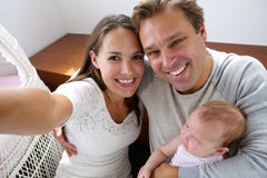 Pares felizes que fotografam-se com bebê fotos de stock Pares felizes que fotografam-se com bebê fotos de stock