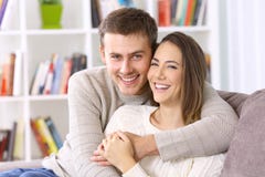 Pares felizes que levantam junto em um sofá em casa foto de stock Pares felizes que levantam junto em um sofá em casa foto de stock