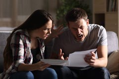 Pares furiosos que leen una letra en casa imágenes de archivo libres de regalías Pares furiosos que leen una letra en casa imágenes de archivo libres de regalías