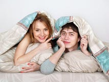 Pares hermosos jovenes bajo lanket en una cama imagenes de archivo Pares hermosos jovenes bajo lanket en una cama imagenes de archivo