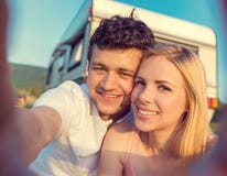 Pares jovenes con una autocaravana imagen de archivo libre de regalías Pares jovenes con una autocaravana imagen de archivo libre de regalías