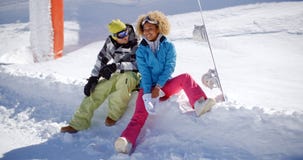 Pares jovenes felices que se relajan en un estante de la nieve imagen de archivo Pares jovenes felices que se relajan en un estante de la nieve imagen de archivo