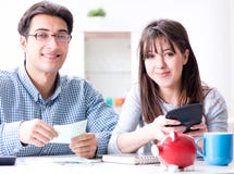 Pares jovenes que miran los papeles de las finanzas de la familia foto de archivo Pares jovenes que miran los papeles de las finanzas de la familia foto de archivo