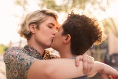 Pares lesbianos jovenes cariñosos que comparten un beso en la ciudad imágenes de archivo libres de regalías Pares lesbianos jovenes cariñosos que comparten un beso en la ciudad imágenes de archivo libres de regalías