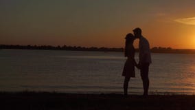 Pares mayores cariñosos que disfrutan de una tarde romántica de la puesta del sol que baila junto en la playa filmada almacen de video Pares mayores cariñosos que disfrutan de una tarde romántica de la puesta del sol que baila junto en la playa filmada almacen de video