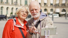 Pares mayores que hacen el selfie con smartphone el vacaciones en París, divirtiéndose que viaja junto almacen de video Pares mayores que hacen el selfie con smartphone el vacaciones en París, divirtiéndose que viaja junto almacen de video