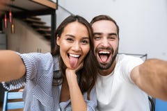 Pares multi-étnicos alegres que tomam um selfie fotografia de stock royalty free Pares multi-étnicos alegres que tomam um selfie fotografia de stock royalty free