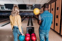 pares multiétnicos con las bolas de bolos que se colocan delante de los callejones imagenes de archivo pares multiétnicos con las bolas de bolos que se colocan delante de los callejones imagenes de archivo