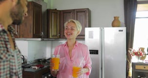 Pares na bebida Juice In Morning alaranjado da cozinha, homem novo e café da manhã de fala da mulher filme Pares na bebida Juice In Morning alaranjado da cozinha, homem novo e café da manhã de fala da mulher filme