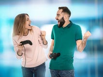 Pares novos emocionais que jogam jogos de vídeo com controladores fotografia de stock Pares novos emocionais que jogam jogos de vídeo com controladores fotografia de stock