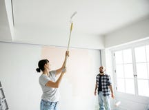 Pares novos que renovam o conceito da casa DIY foto de stock royalty free Pares novos que renovam o conceito da casa DIY foto de stock royalty free