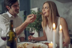 Pares que apreciam um jantar rom?ntico pela luz de vela imagem de stock Pares que apreciam um jantar rom?ntico pela luz de vela imagem de stock