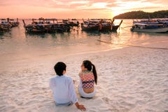 Pares que relajan la puesta del sol hermosa en Koh Lipe Beach Thailand, vacaciones de verano imagenes de archivo Pares que relajan la puesta del sol hermosa en Koh Lipe Beach Thailand, vacaciones de verano imagenes de archivo