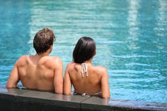 Pares que se relajan en centro turístico de la piscina del infinito imagen de archivo libre de regalías Pares que se relajan en centro turístico de la piscina del infinito imagen de archivo libre de regalías