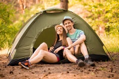 Pares românticos que acampam fora e que sentam-se na barraca Homem e mulher felizes em férias de acampamento fotografia de stock Pares românticos que acampam fora e que sentam-se na barraca Homem e mulher felizes em férias de acampamento fotografia de stock