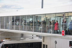 Paris, France - avril 2016 : Les gens embarquant un airplain utilisant un pont transparent en jet Vue de côté de terminal photo libre de droits Paris, France - avril 2016 : Les gens embarquant un airplain utilisant un pont transparent en jet Vue de côté de terminal photo libre de droits