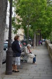 PARIS, FRANCE - MARCH 29, 2014:Women sitting reading a book on the Seine river stock image PARIS, FRANCE - MARCH 29, 2014:Women sitting reading a book on the Seine river stock image