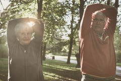 Parkerar den koppla av och arbetande övningen för höga par tillsammans i fotografering för bildbyråer Parkerar den koppla av och arbetande övningen för höga par tillsammans i fotografering för bildbyråer