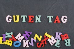 Parola dell'ETICHETTA di GUTEN sul fondo nero composto dalle lettere di legno di ABC del blocchetto variopinto di alfabeto, spazi fotografia stock libera da diritti Parola dell'ETICHETTA di GUTEN sul fondo nero composto dalle lettere di legno di ABC del blocchetto variopinto di alfabeto, spazi fotografia stock libera da diritti