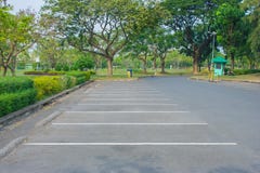 Parque vazio do parque de estacionamento do carro do espaço em público com as árvores verdes no fundo imagem de stock royalty free Parque vazio do parque de estacionamento do carro do espaço em público com as árvores verdes no fundo imagem de stock royalty free