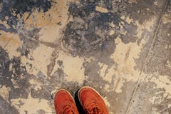 Part of red sneakers on the surface of the old plaster floor. stock photography Part of red sneakers on the surface of the old plaster floor. stock photography