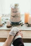 partial view of newlyweds holding hands while sitting at served table with wedding cake, rustic stock photos partial view of newlyweds holding hands while sitting at served table with wedding cake, rustic stock photos