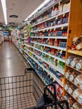 Partial view of a shopping cart as it navigates through a QFC grocery store, in the spices, seasonings, and oils aisle
