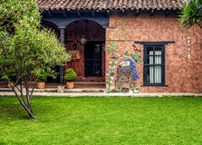 Partial view of a vintage house behind a lush grass field stock photo Partial view of a vintage house behind a lush grass field stock photo