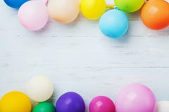 Party or birthday banner with colorful balloons on blue wooden background top view. Flat lay style.