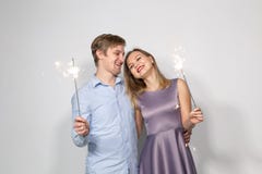 Party, family and holidays concept - young couple holding sparklers on white background stock images Party, family and holidays concept - young couple holding sparklers on white background stock images
