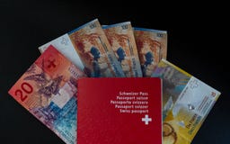 Pasaporte suizo y dinero cercanos para arriba en la ciudadanía negra de Suiza del fondo imagenes de archivo Pasaporte suizo y dinero cercanos para arriba en la ciudadanía negra de Suiza del fondo imagenes de archivo