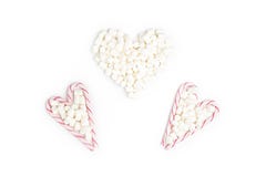 Pasiaści lizaki i Marshmallow w formie trzy serca obrazy stock Pasiaści lizaki i Marshmallow w formie trzy serca obrazy stock