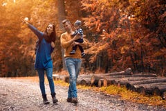 Passeggiate nel bosco di una coppia dei giovani con un ragazzino Fotografia Stock Passeggiate nel bosco di una coppia dei giovani con un ragazzino Fotografia Stock