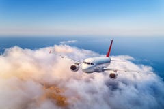 Passenger airplane flying over clouds at sunset stock images Passenger airplane flying over clouds at sunset stock images