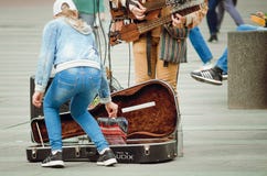 Passersby ger pengar till en gatamusiker royaltyfri bild Passersby ger pengar till en gatamusiker royaltyfri bild