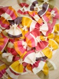 Pasta farfalle,Italian pasta pattern on a wood plate. Various colors of bow tie farfalle pasta viewed from above. Top view. Repeti royalty free stock photography Pasta farfalle,Italian pasta pattern on a wood plate. Various colors of bow tie farfalle pasta viewed from above. Top view. Repeti royalty free stock photography