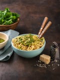 Pasta spaghetti with spinach pesto sauce, walnut and fresh raw spinach leaves in bowl. dark background. Healthy eating, vegetarian stock photography Pasta spaghetti with spinach pesto sauce, walnut and fresh raw spinach leaves in bowl. dark background. Healthy eating, vegetarian stock photography