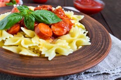 Pasta in una ciotola ceramica, servire di Farfalle con ketchup, pomodori freschi, salsiccia in salsa al pomodoro Immagine Stock Libera da Diritti Pasta in una ciotola ceramica, servire di Farfalle con ketchup, pomodori freschi, salsiccia in salsa al pomodoro Immagine Stock Libera da Diritti