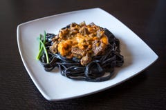 Pastas negras con tinta de las jibias Pastas de la sémola del trigo de trigo duro con tinta del calamar con la salsa de la carne foto de archivo libre de regalías Pastas negras con tinta de las jibias Pastas de la sémola del trigo de trigo duro con tinta del calamar con la salsa de la carne foto de archivo libre de regalías