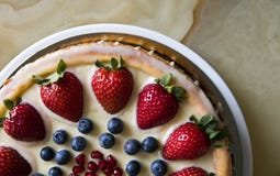 Pastel de queso con las fresas y los arándanos en una tabla de mármol imagenes de archivo Pastel de queso con las fresas y los arándanos en una tabla de mármol imagenes de archivo